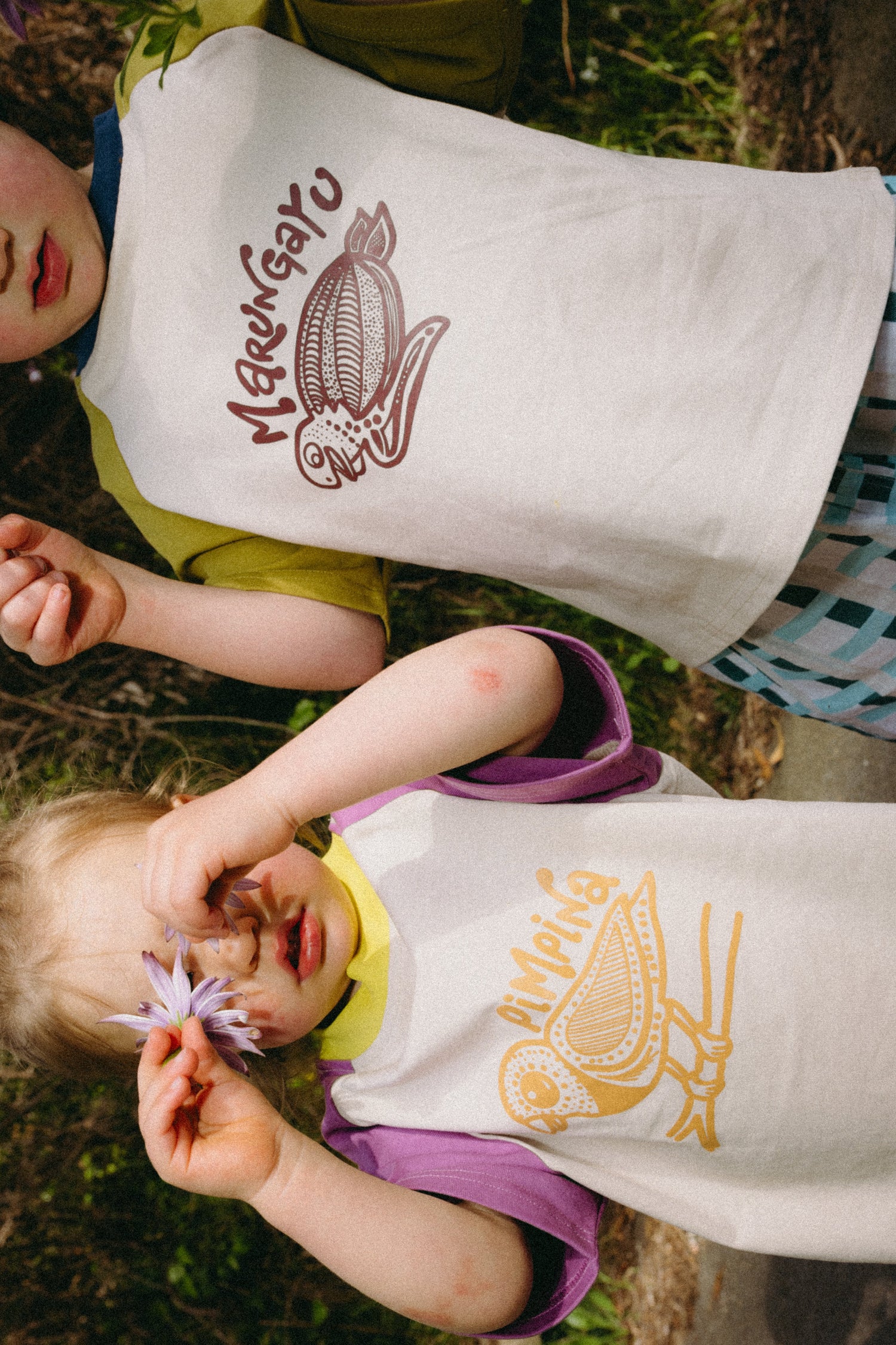 two kids wearing T-shirts with indigenous illustrations